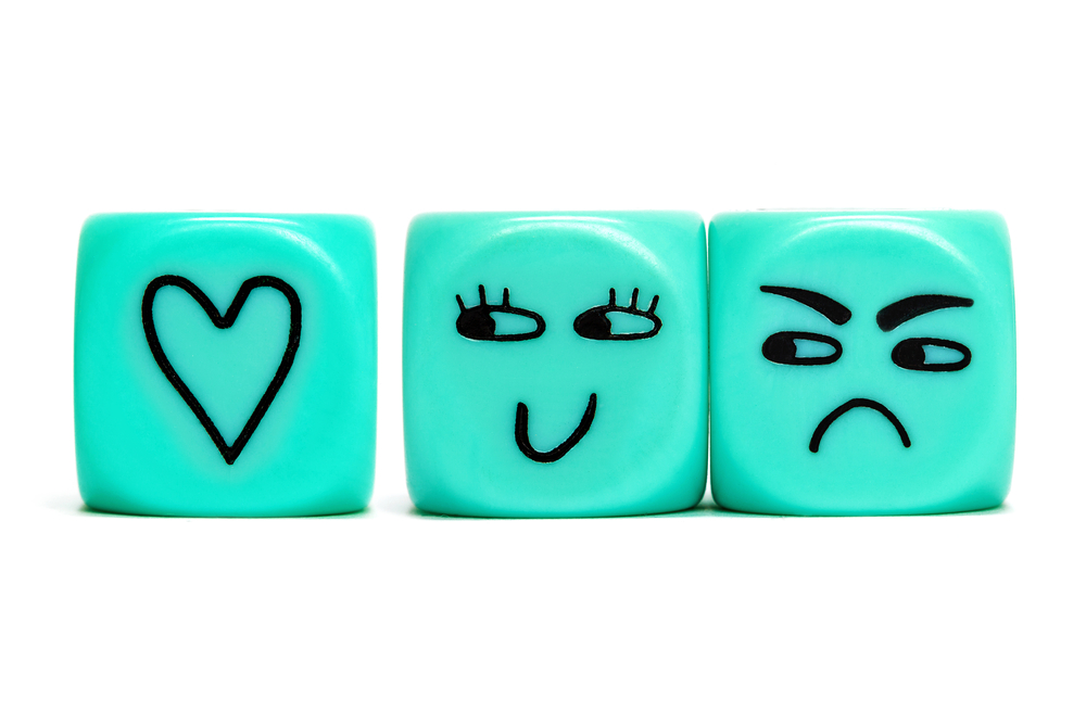 Dice with happy and sad faces on them