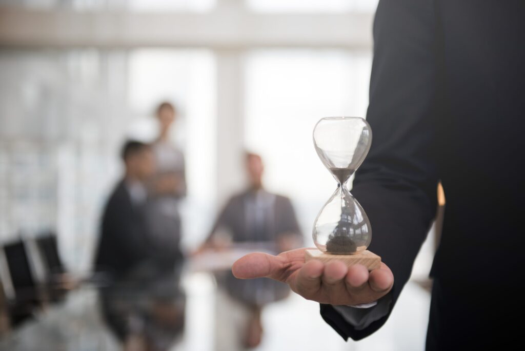 Executive holds hourglass running out of time