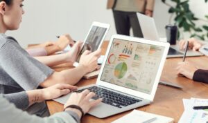 Employees look at data charts on laptops