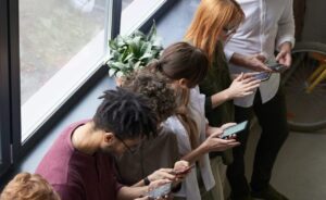 Customers in a row take surveys on phones