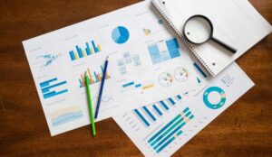 Different chart types on papers with magnifying glass